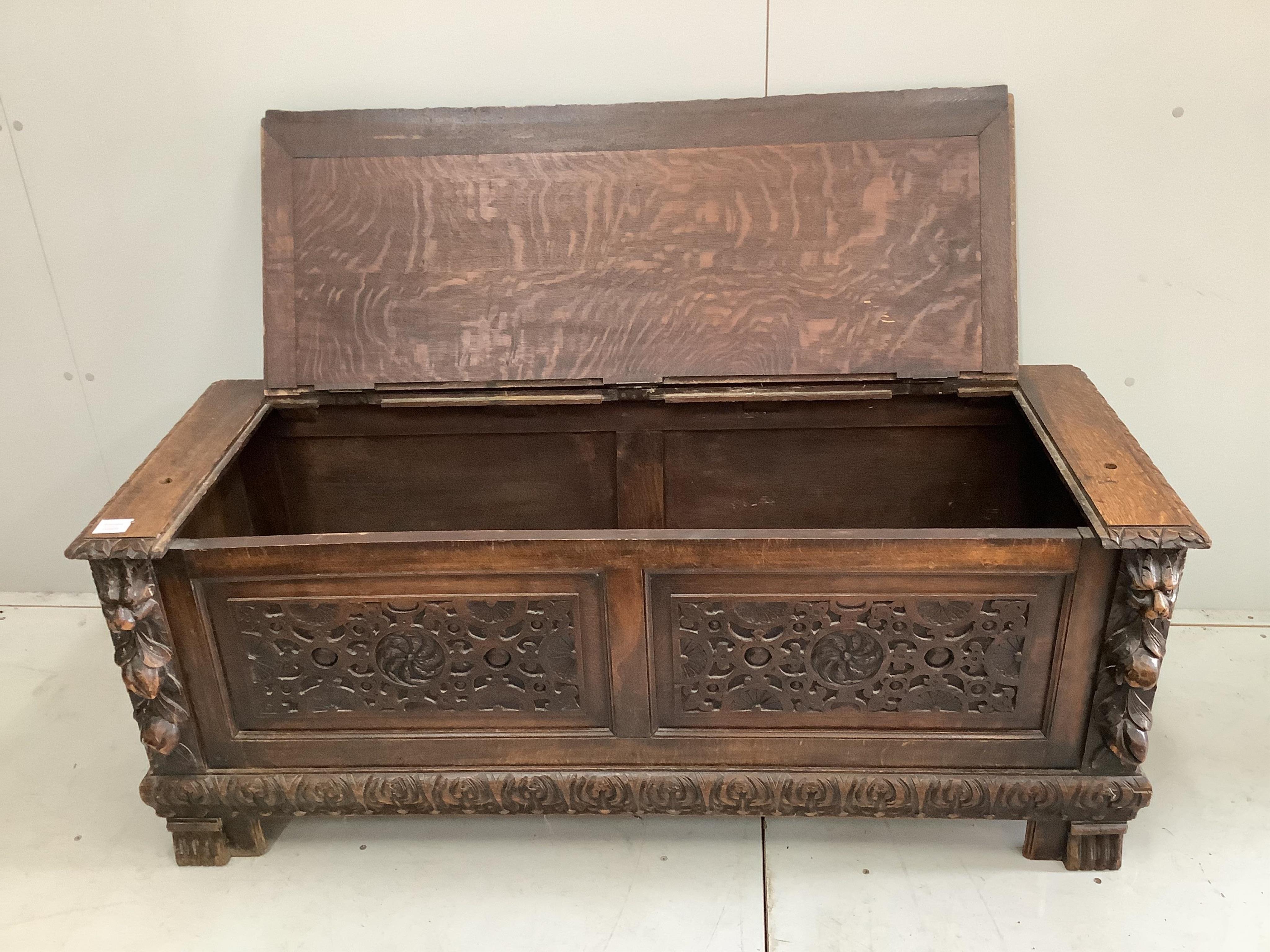 An early 20th century carved oak coffer formerly a monk's bench, width 137cm. Condition - lacking original arms and back, otherwise fair